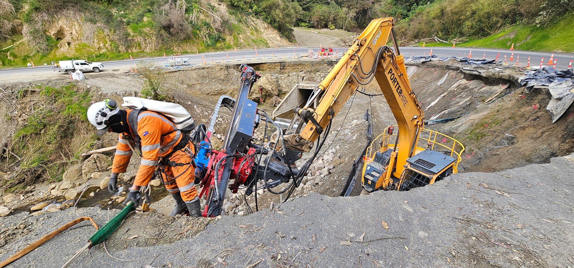Aerial view of GSI excavator and crew responding to an active road failure in NZ native bush